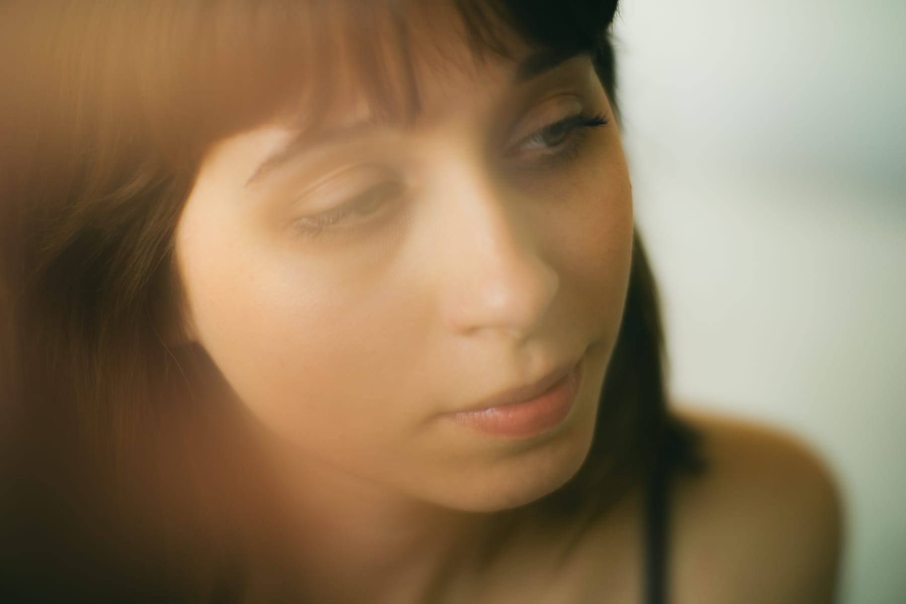 Soft-focus close-up of Bogi, dark hair and fringe, looking down.