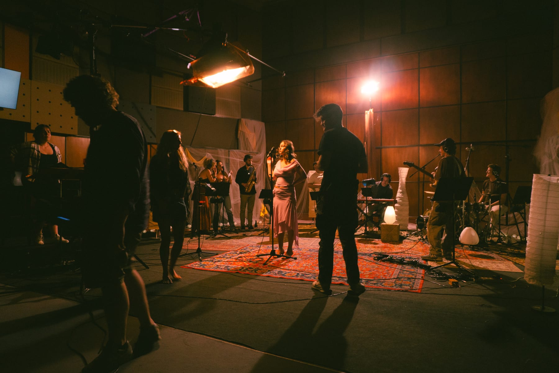 The Pati Piko live session in half-light: silhouettes in front, the band and studio lights behind.